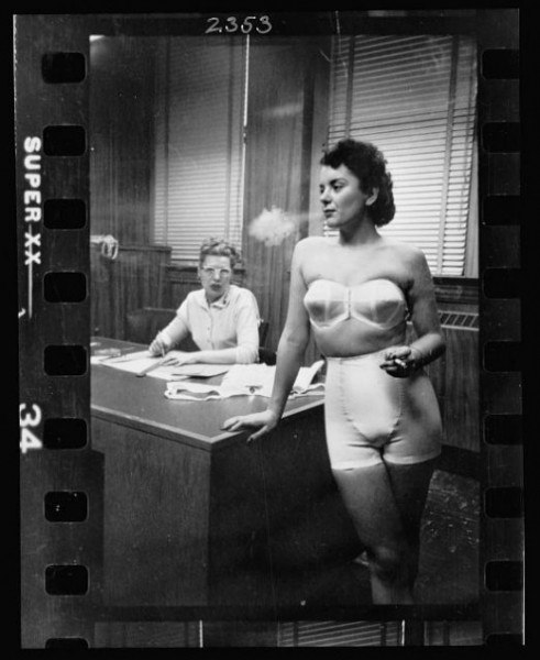 04-22.-Woman-model-standing-in-an-office-smoking-while-modeling-undergarments-520x635-491x600