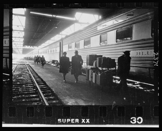 07-2.-A-man-and-a-woman-walking-with-a-porter-on-the-platform-next-to-a-railroad-passenger-car-at-the-train-station-520x420
