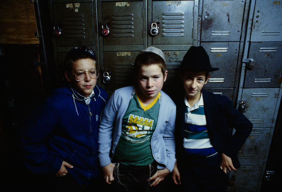 Three adolescent Jewish boys, their heads traditionally covered with skullcaps or top hats, sitting in front of school lockers in Brooklyn, June 1982.Photograph by Robert Madden, National Geographic