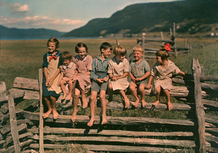 Seven siblings sit on a wooden fence in Quebec, Canada, May 1939.Photograph by Howell Walker, National Geographic