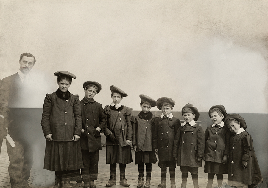 A man stands next to orphaned Russian Jews upon immigration to the U.S., New York, July 1919.