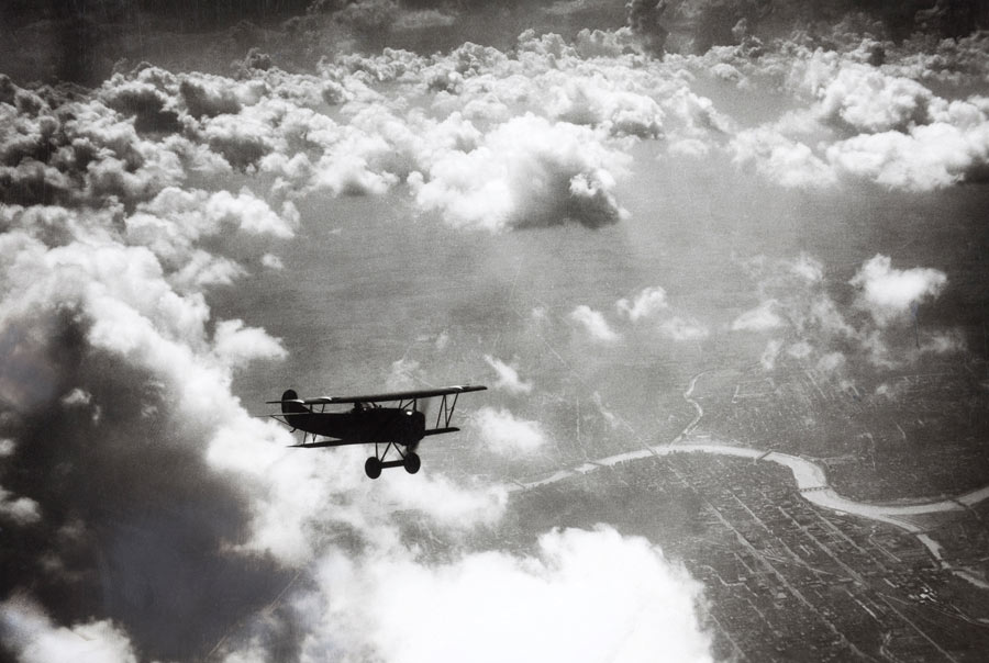 A plane flies above the clouds at Dayton, Ohio, July 1924. Photograph by Samuel Burka, National Geographic