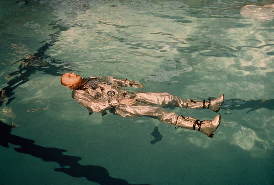 Astronaut Neil Armstrong floats in his space suit in a pool of water in 1967. Photograph by NASA