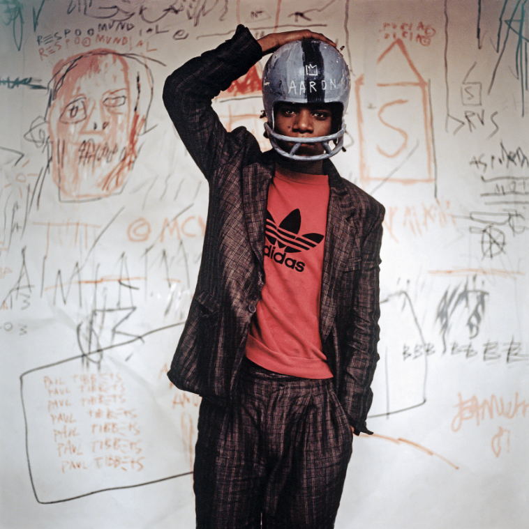 Edo Bertoglio. Jean-Michel Basquiat wearing an American football helmet, 1981. (Photo: © Edo Bertoglio, courtesy of Maripol. Artwork: © The Estate of Jean-Michel Basquiat. Licensed by Artestar, New York)