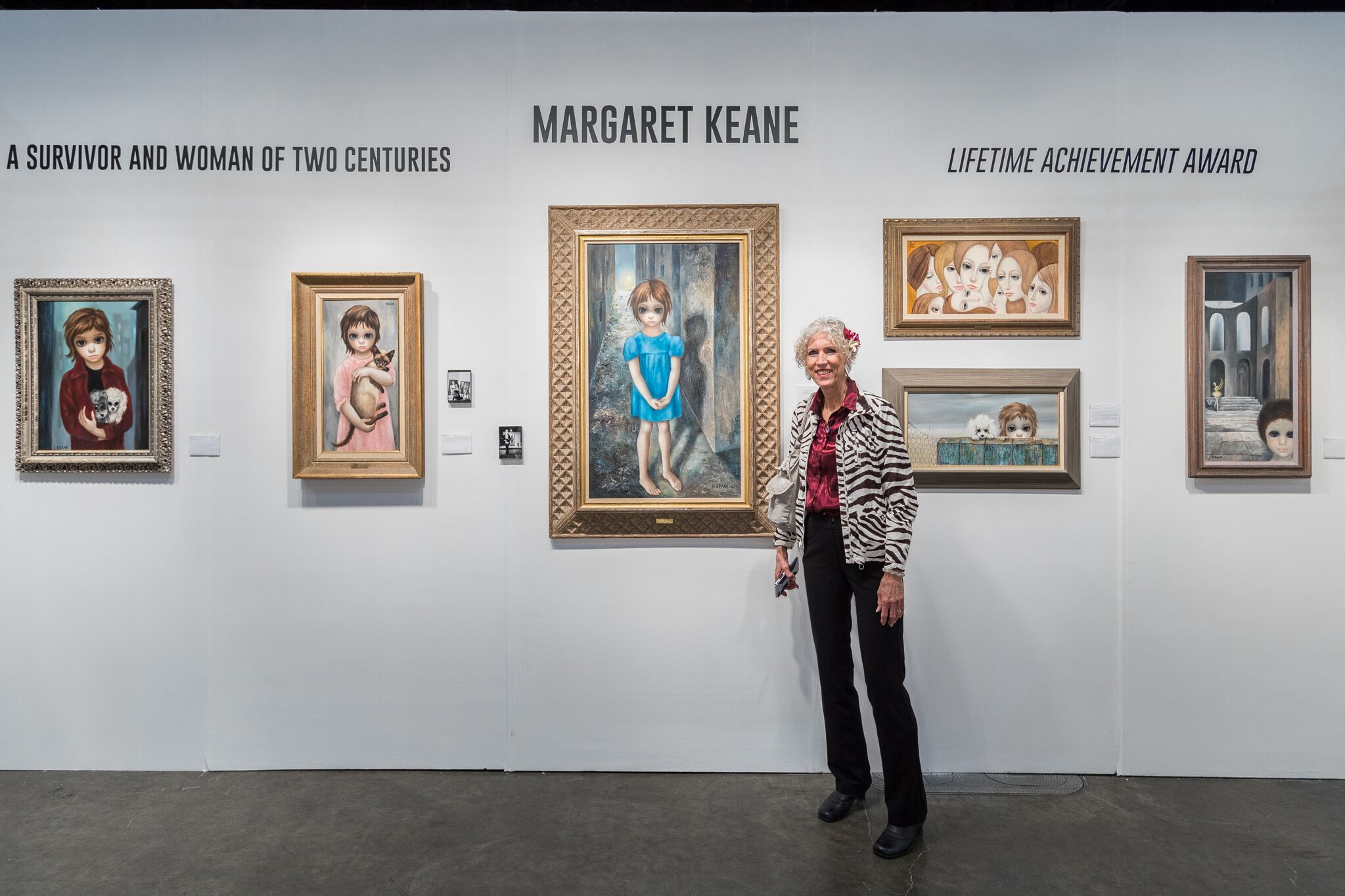 Margaret Keane with some of her paintings