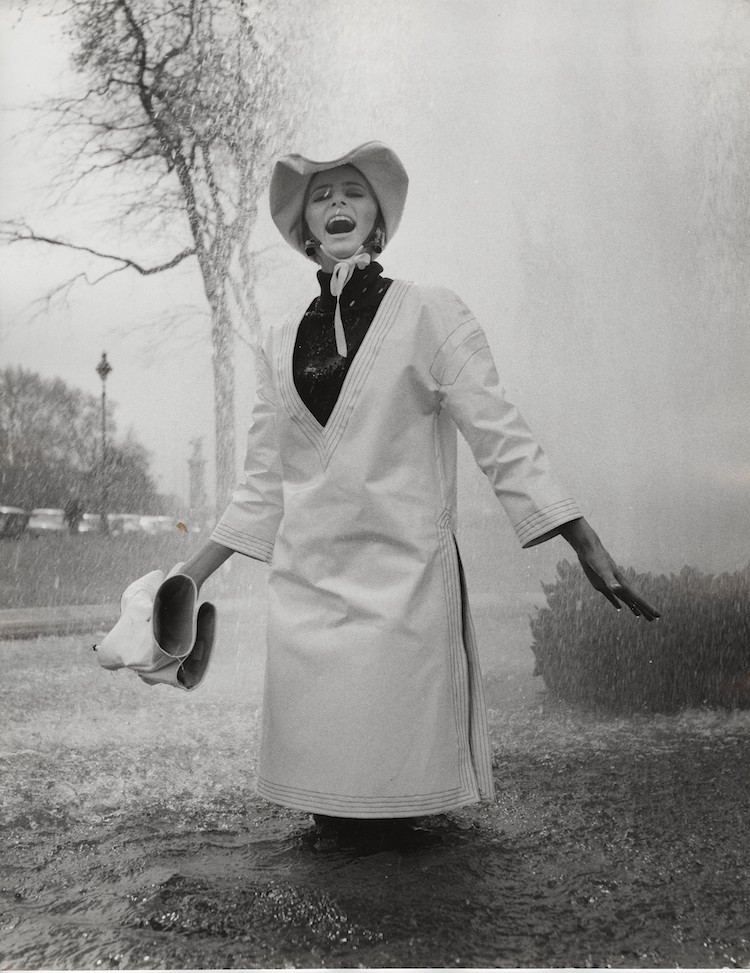 Jill Kennington wearing white PVC rain tunic and hat. Photograph by  John Cowan, 1963 Courtesy of Fashion Museum Bath/Image © John  Cowan Archive