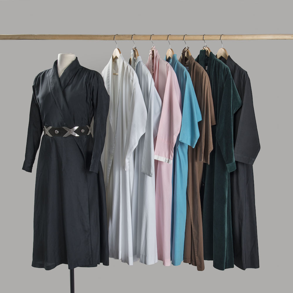 Eight Wrap Dresses. Left to right: Black cotton, c. 1960s–70s; White cotton, Carol Sarkisian, c. 1970s; Blue-gray cotton, c. 1960s; Pink cotton, Neiman Marcus, c. late 1950s; Blue cotton, Neiman Marcus, c. late 1950s; Brown cotton, Sidran, Inc., c. late 1950s; Green synthetic velvet, Carol Sarkisian, c. 1970s; Black cotton, c. 1960s– 70s. Georgia O’Keeffe Museum, 2000.03.0602, 2000.03.0410, 2000.03.0411, 2000.03.0398, 2000.03.0394, 2000.03.0419, 2000.03.0357, and 2000.03.0601. (Photo © Georgia O’Keeffe Museum)