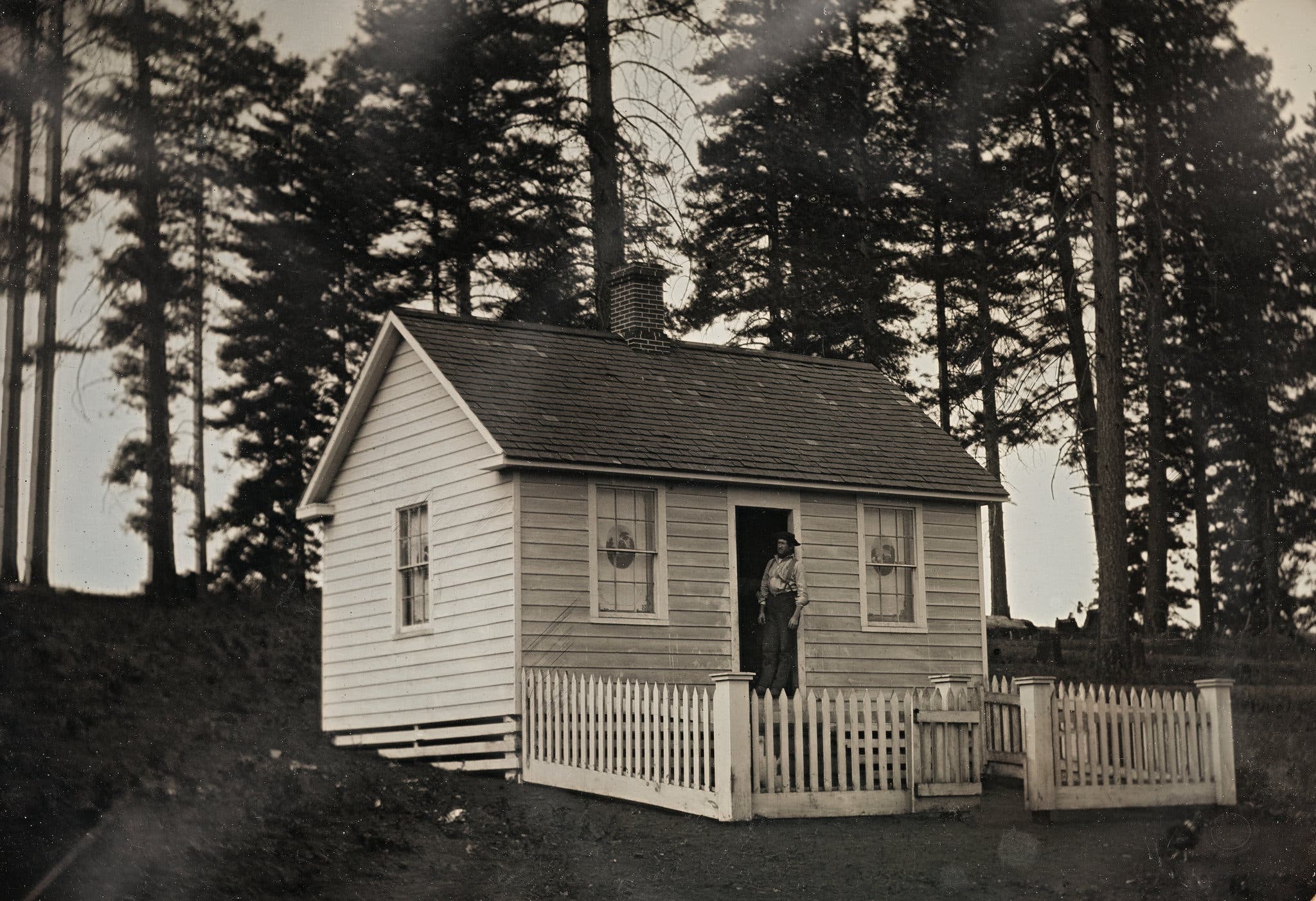 A man stands in the doorway of a prefabricated house. Circa 1855. © Canadian Photography Institute