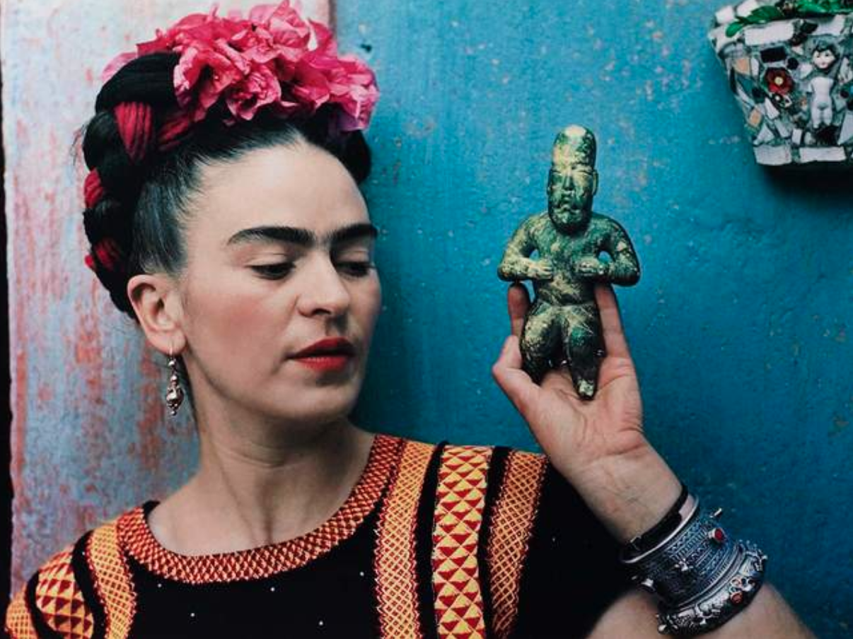 Nickolas Muray, "Frida with Olmeca Figurine, Coyoacán," 1939. Color carbon print, 10 3/4 x 15 3/4 in. (27.3 x 40 cm). Fine Arts Museums of San Francisco, Gift of George and Marie Hecksher in honor of the tenth anniversary of the new de Young museum. 