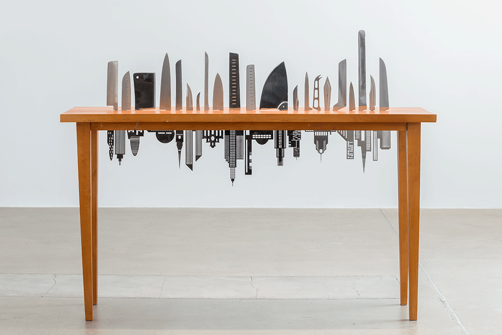 Carlos Garaicoa, “Las raíces del mundo / The Roots of the World,” 2016, wood table, laser-cut stainless steel, and knife handles, 35 1/2 x 19 5/8 x 63 in. Courtesy of the artist and Galleria Continua.