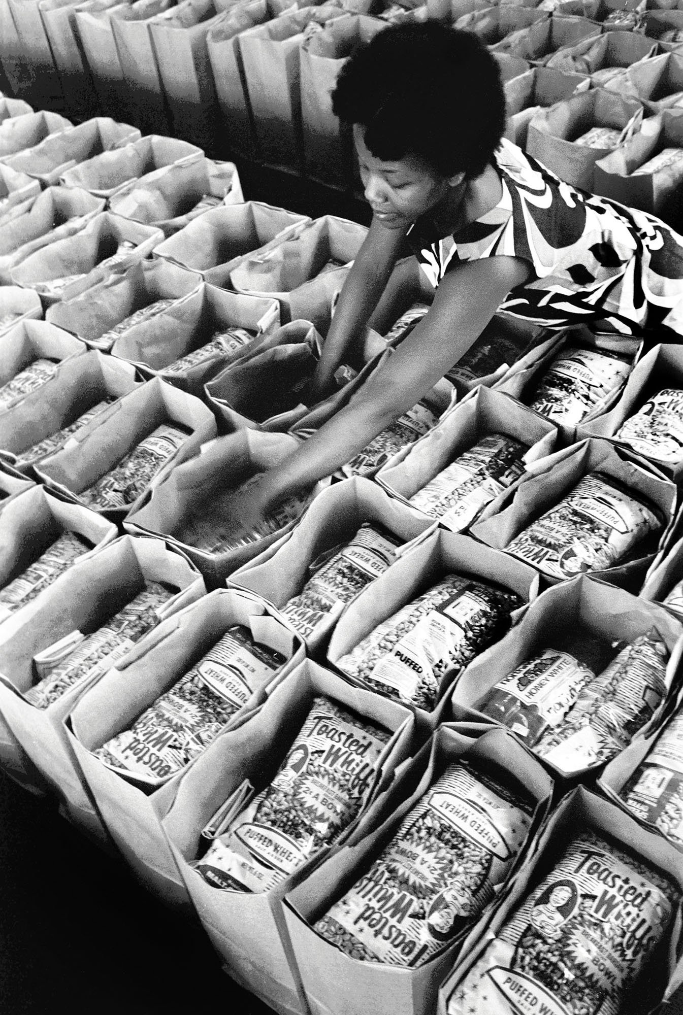 March, 197 2 - Oakland, California: Panther Free Food Program. Earlene Coleman, Black Panther Party member prepares bags of food for distribution at the Laney College student center for the Black Panther Community Survival Conference at the Oakland Coliseum where the Panthers gave away 6,000 bags of groceries. Bobby Seale announced his run for Mayor of Oakland that night.