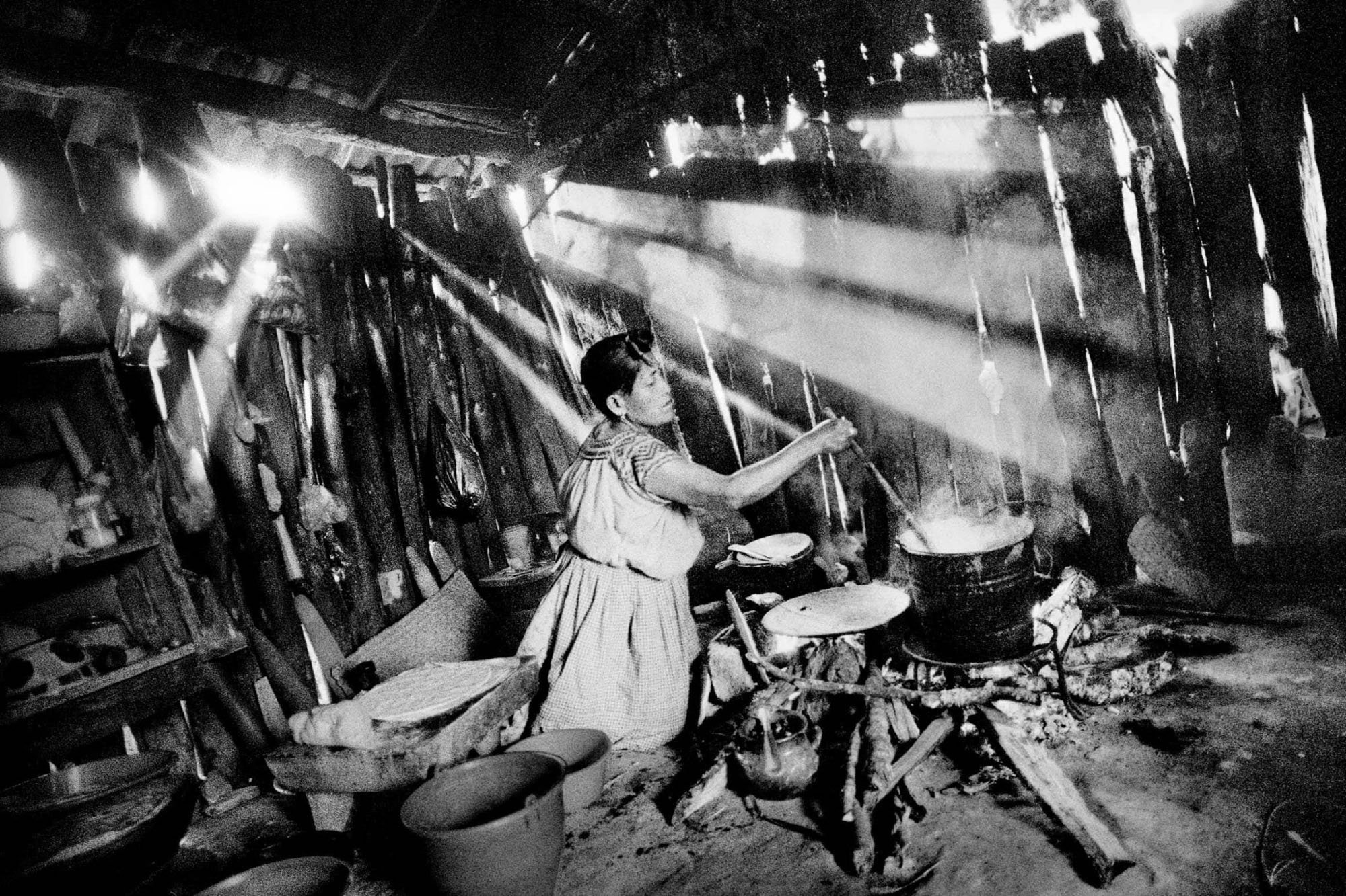 San Miguel Cuevas, Oaxaca. 2006. A woman cooks in the kitchen of her home., 2006