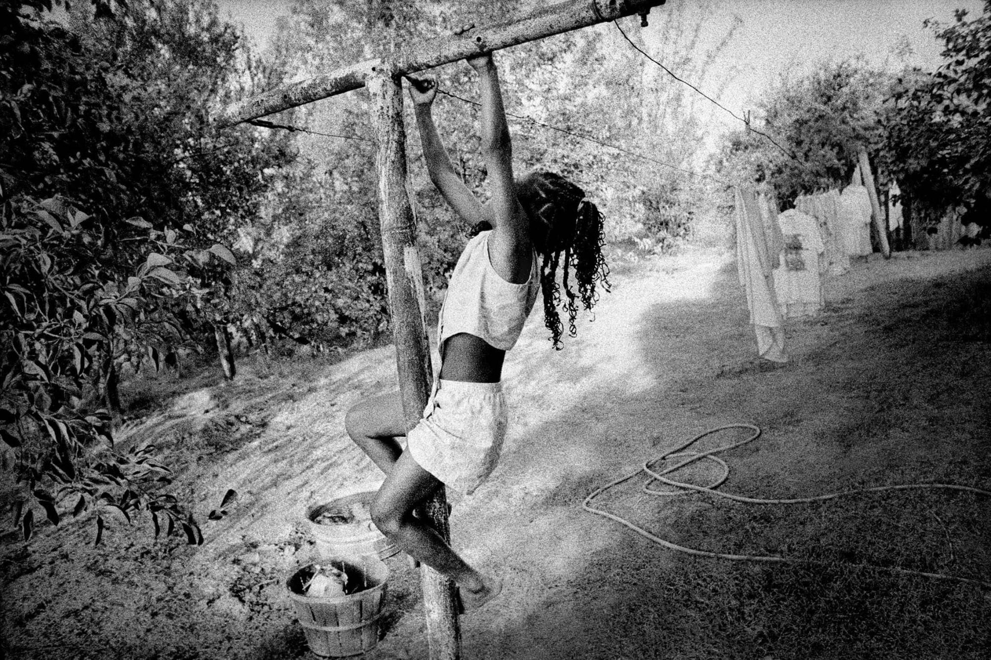 Teviston, California. 2000. Playing on clothesline., 2000