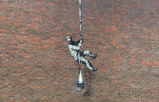New Banksy Work Shows Man Who Resembles Oscar Wilde Scaling Down a Wall at the Old Reading Prison
